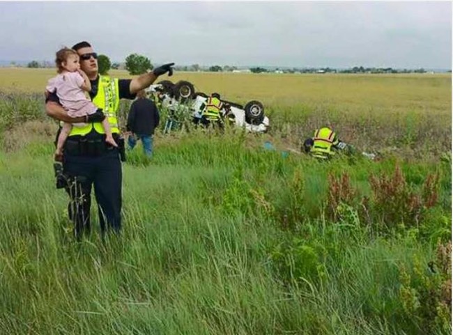 A police officer comforts a toddler in the face of tragedy